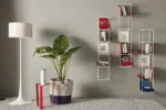 Libro Verticale prende il nome dalla particolare angolazione della mensola, leggermente inclinata indietro per far sì che i libri, cataloghi ed oggetti non cadano mai, restando sempre in posizione verticale.
